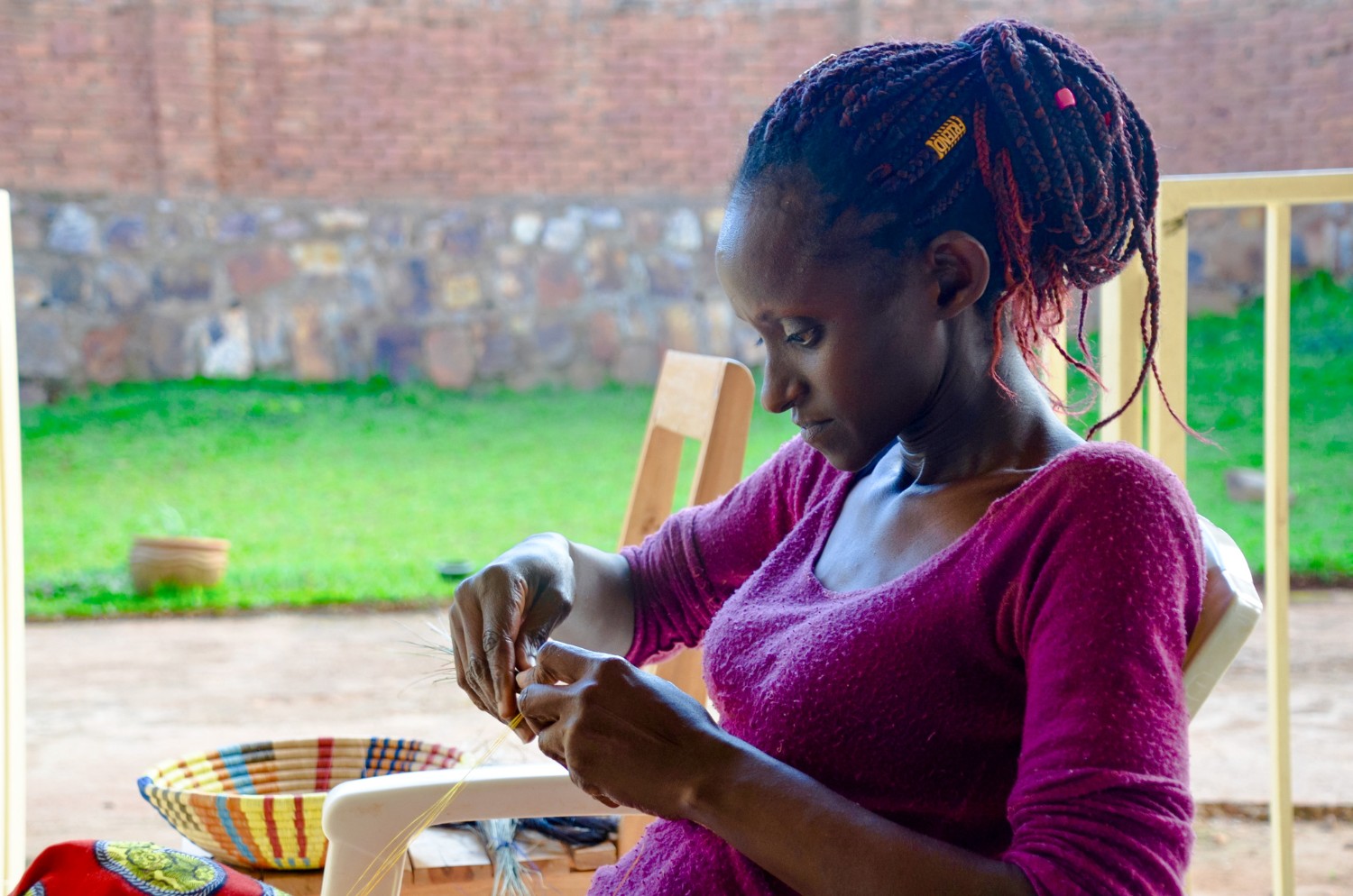 A Rwandese woman weaving a peace basket at Talking Through Art, a women\'s weaving cooperative